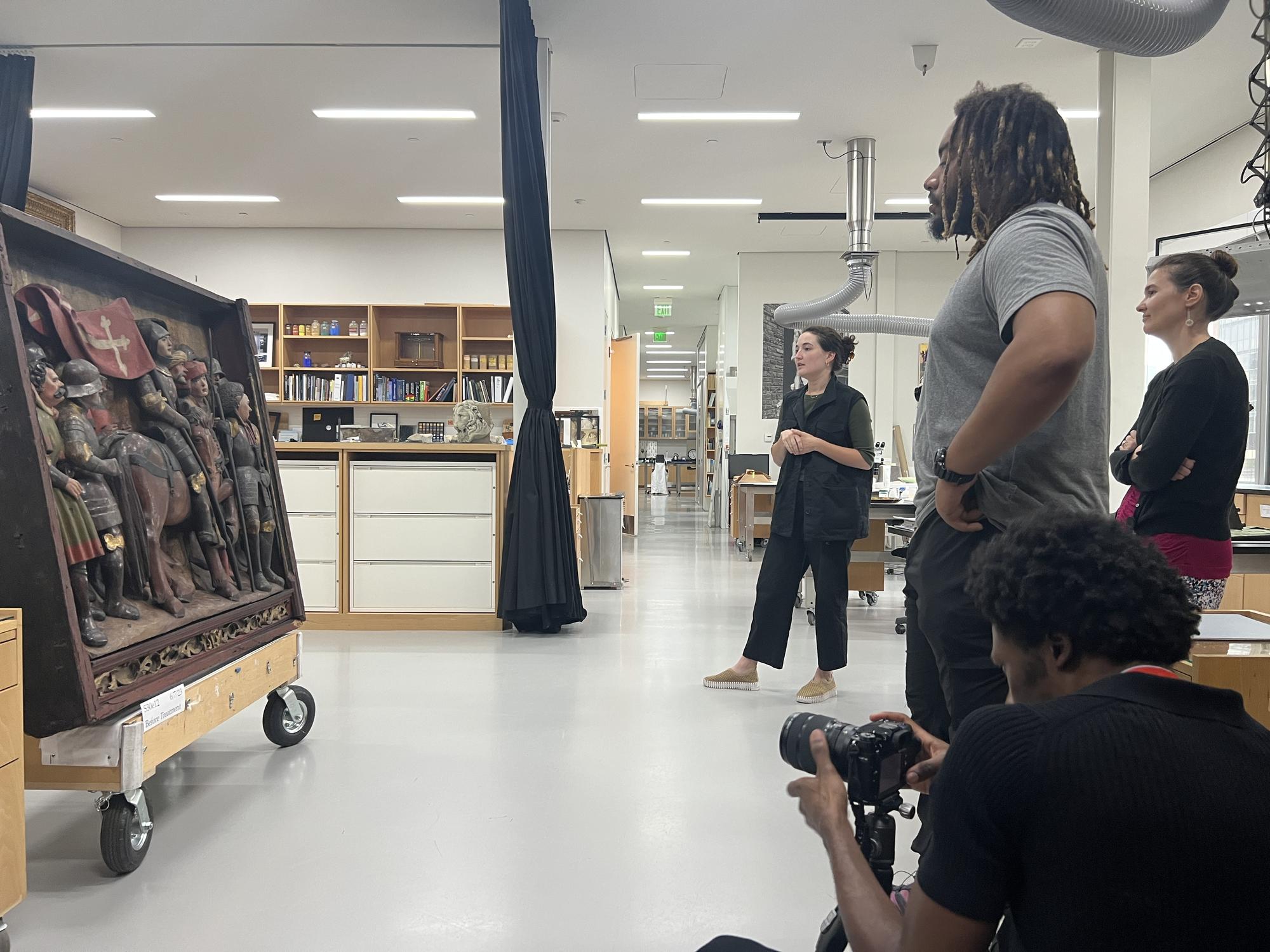 Four people studying a piece of art work in the conservation deparment 