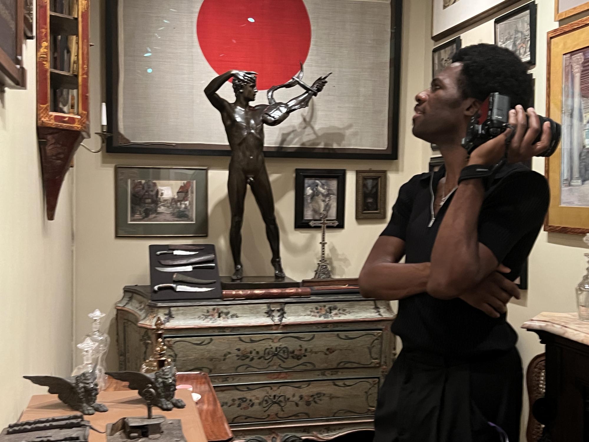 Man looking at a statue in the Vatiicino area of the museum. Flag of Japan in the background. 