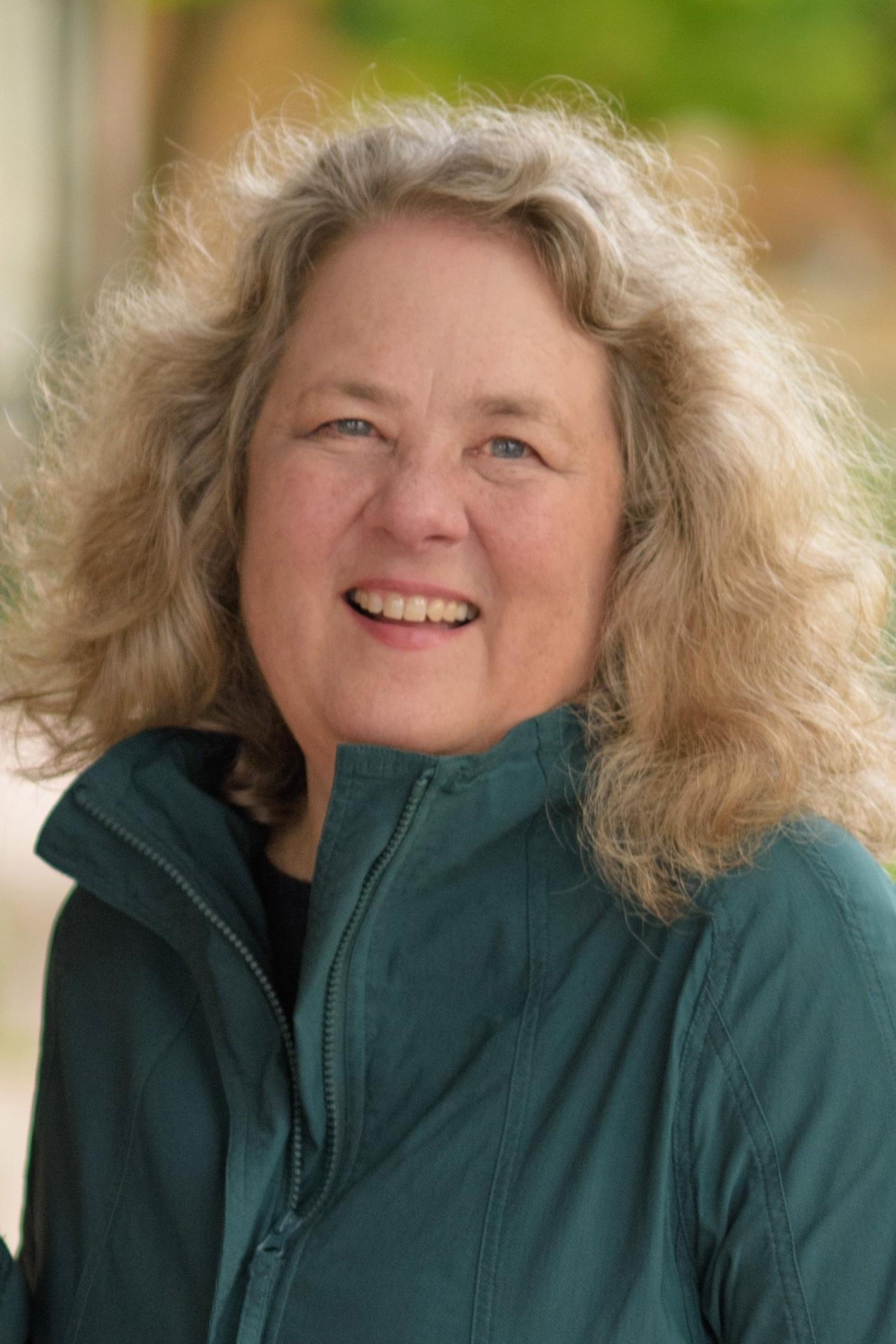 Woman with shoulder-length blond, wavy hair. 