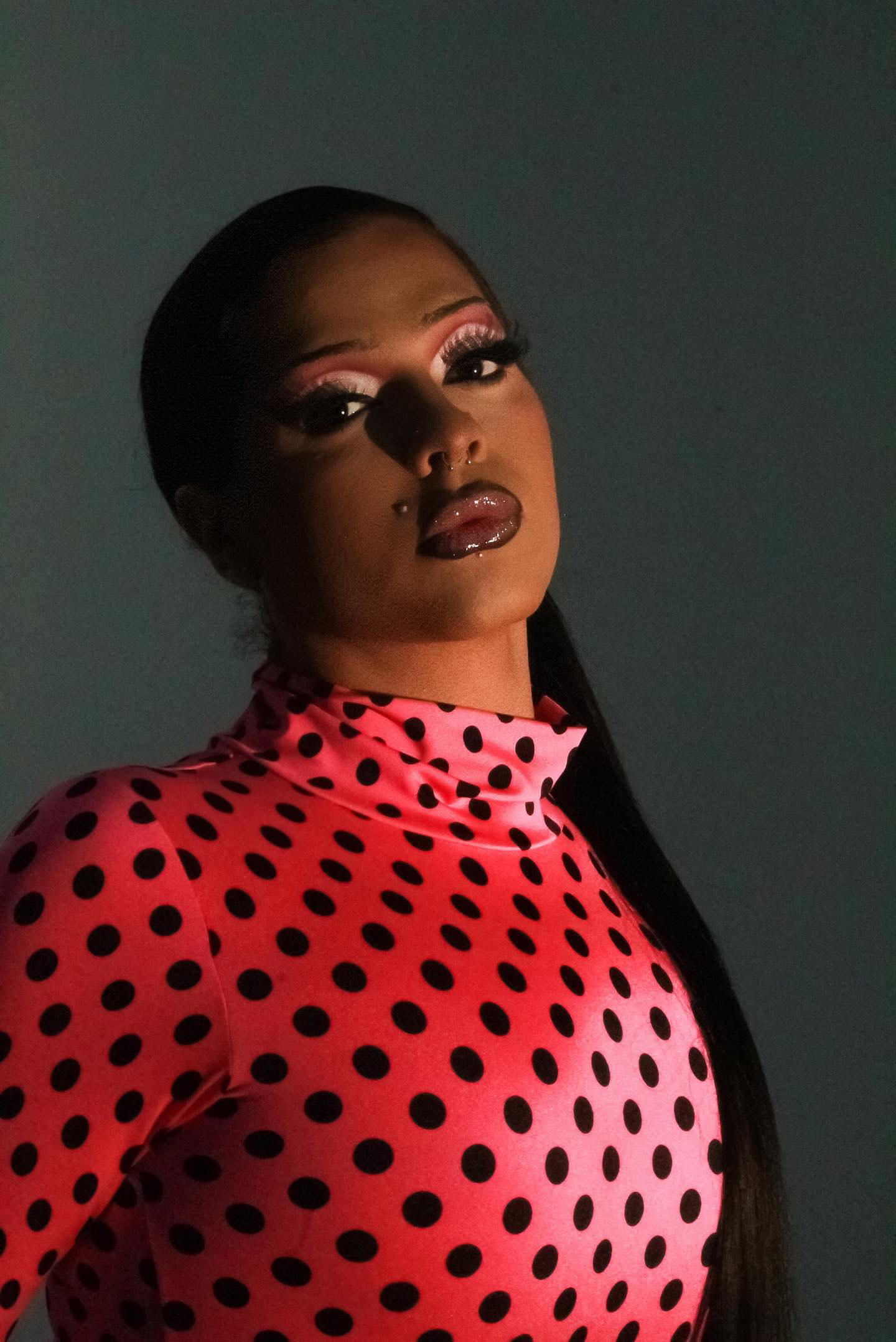 African American woman with long hair in a red and black polka dot top