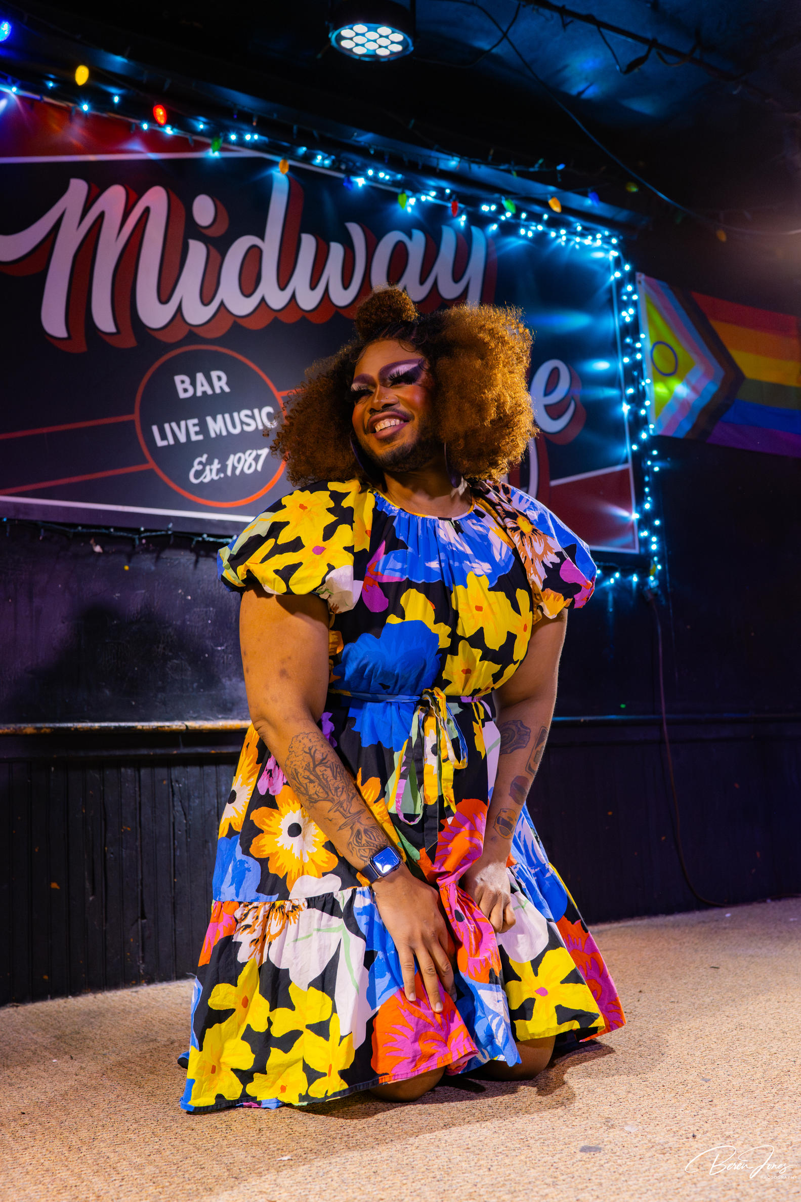 Person kneeling on floor with bright floral dress on