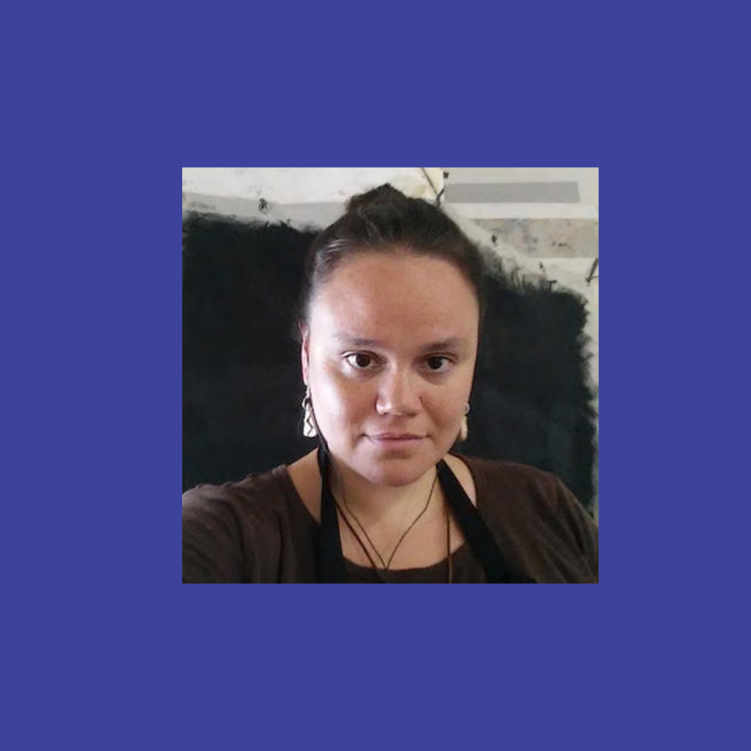 Young woman with dark hair pulled back in a bun,looking straight at the camera