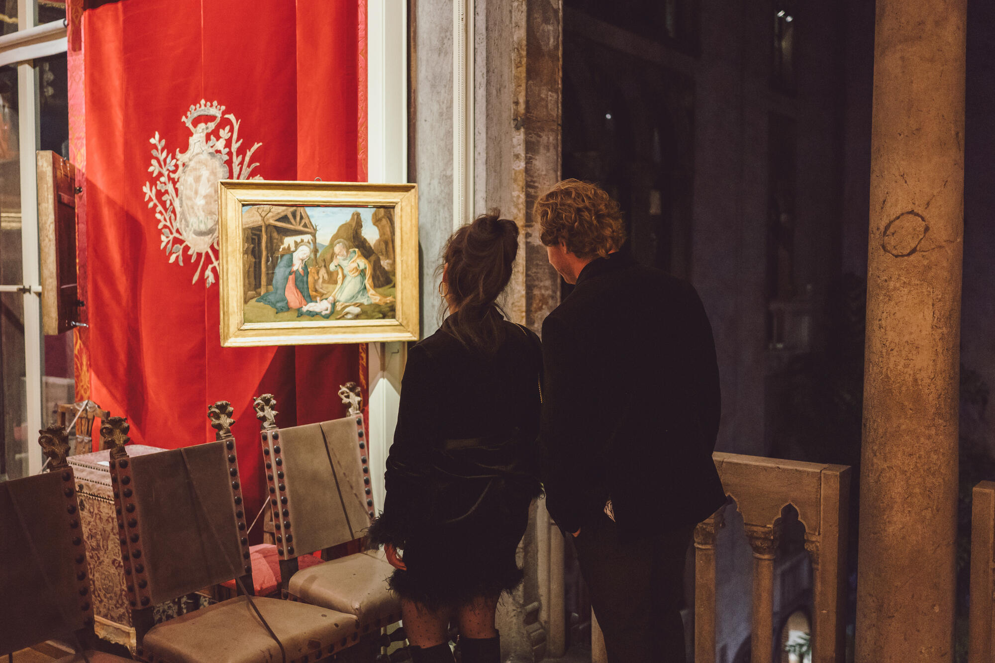 A man and woman looking at a painting during the Velvet Party. 