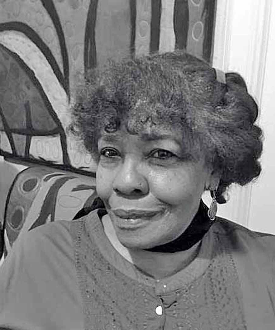 Black and white photograph of an African American woman with short, grey, curly hair looking directly at the camera 