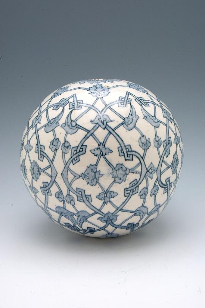 White ceramic egg with blue glazed designs of interlocking arabesque motifs.