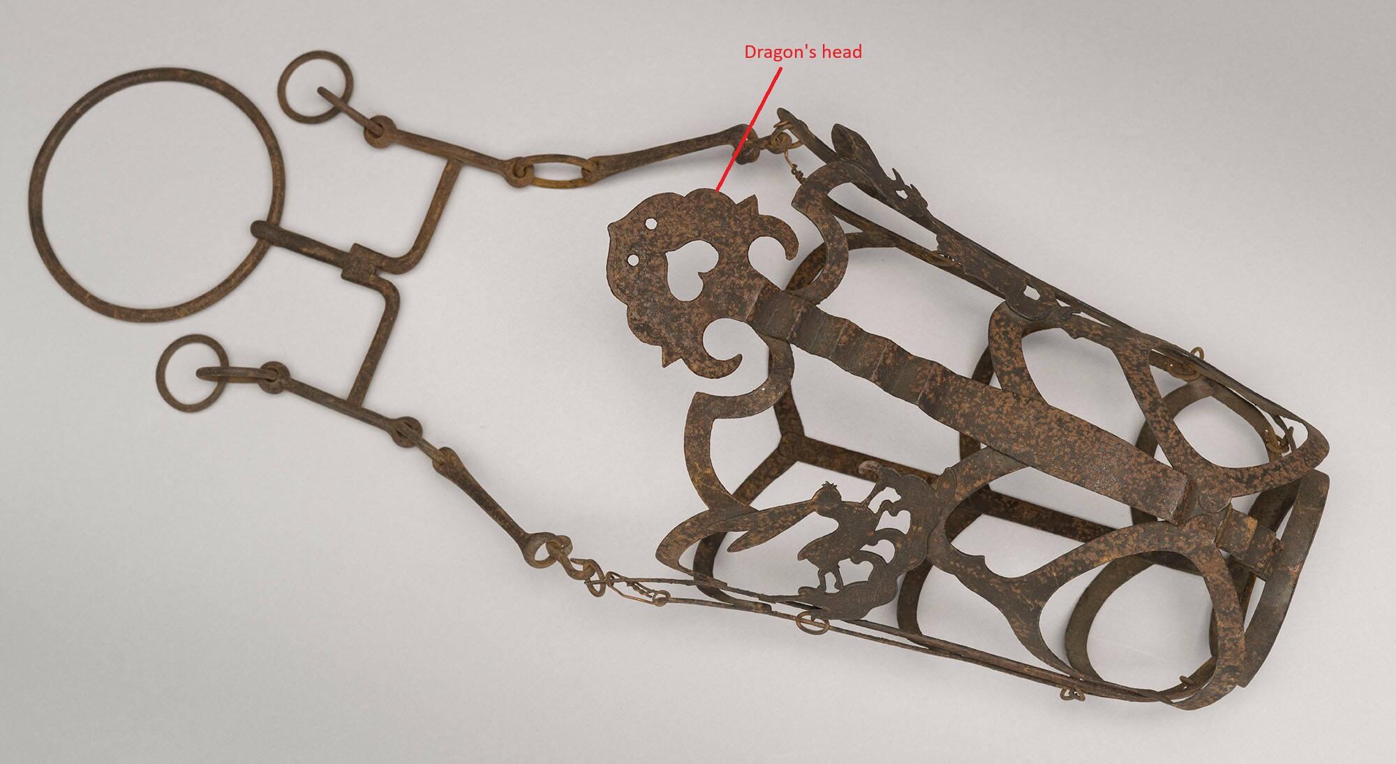 An iron horse muzzle with a dragon head and spine and a rabbit on a cloud.