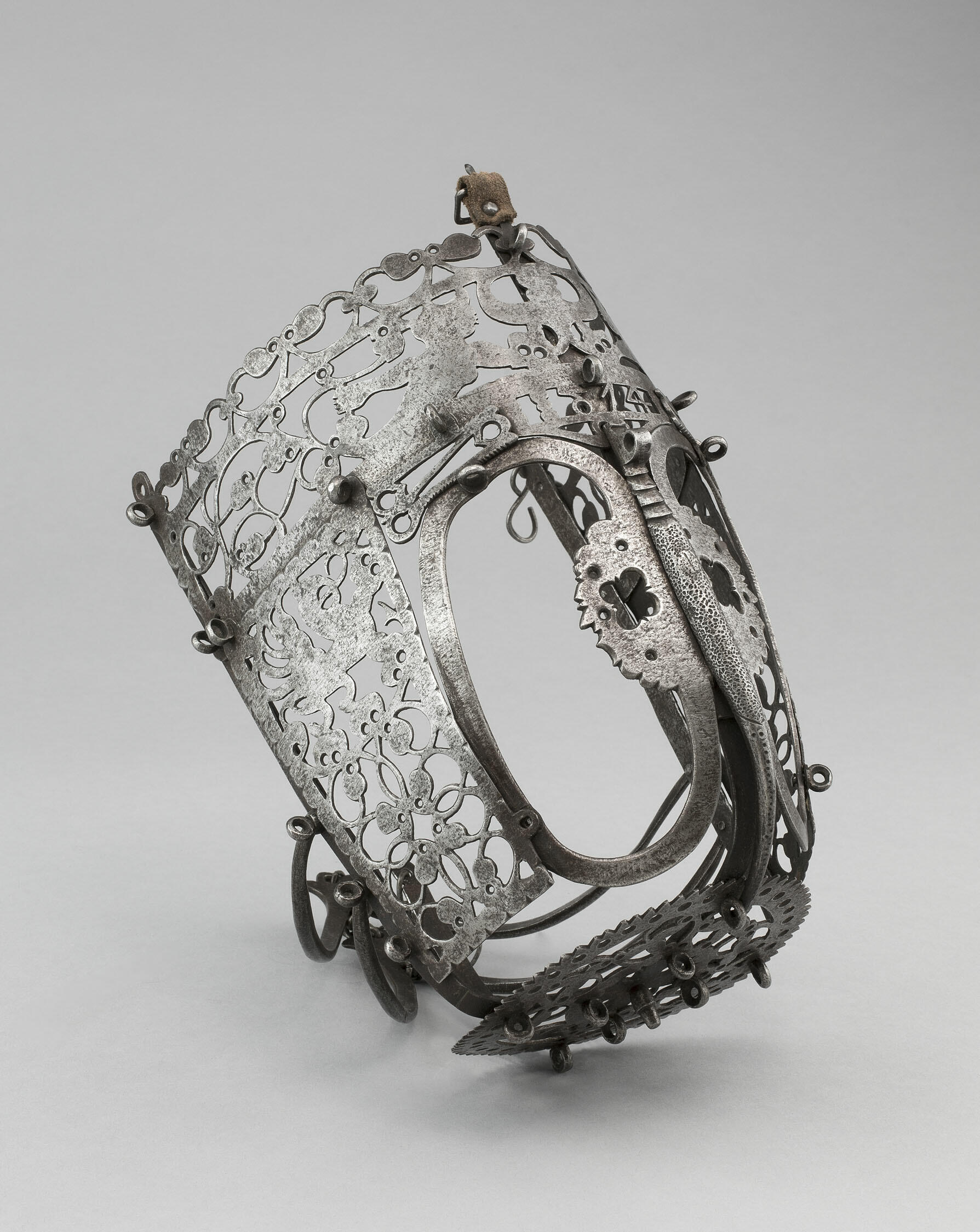 An elaborately decorated metal horse muzzle.