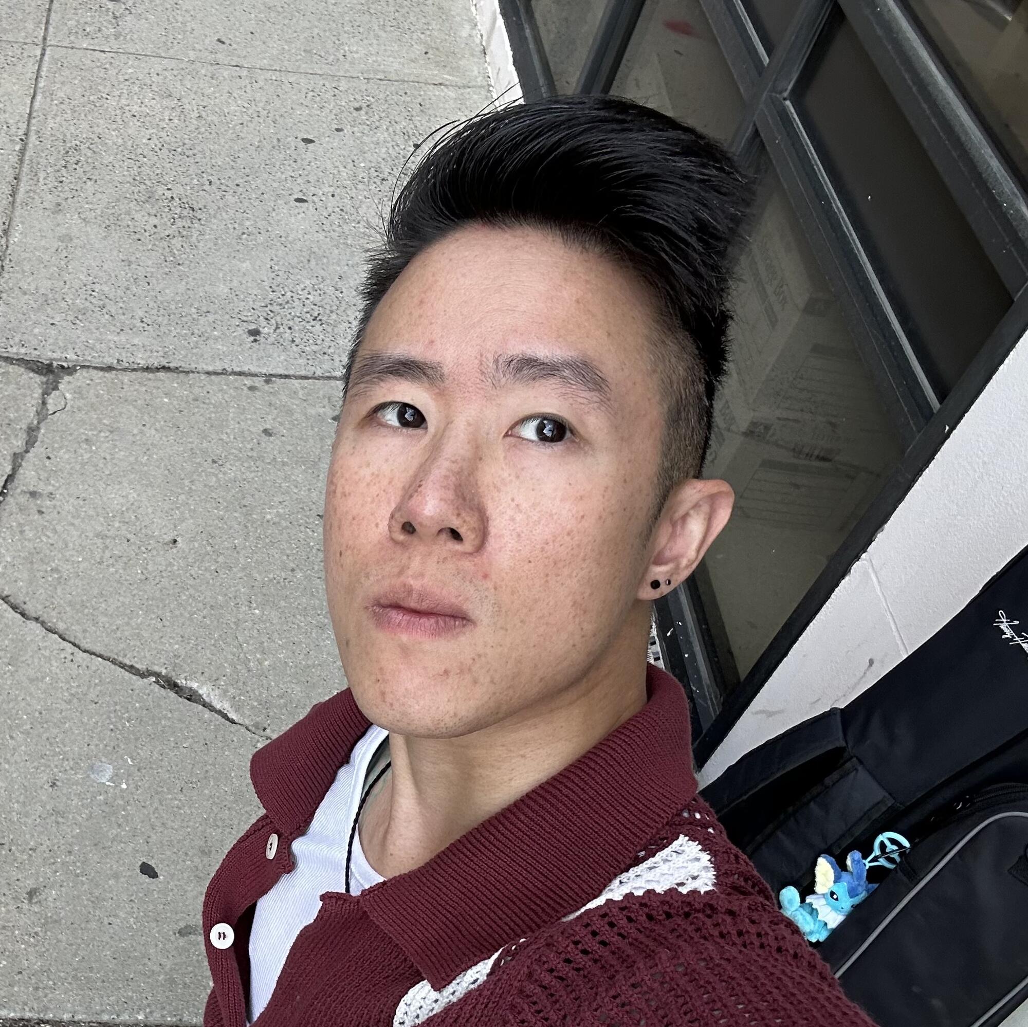 Young Asian man headshot looking up to the camera