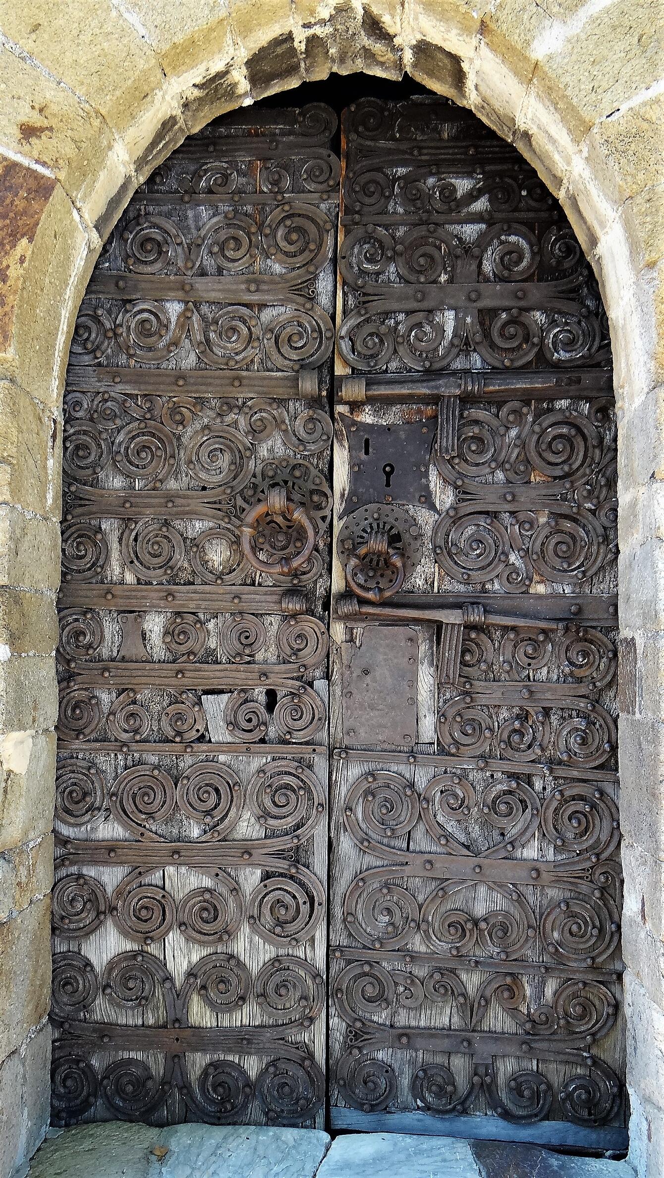 An arched door with scrolling ironwork.