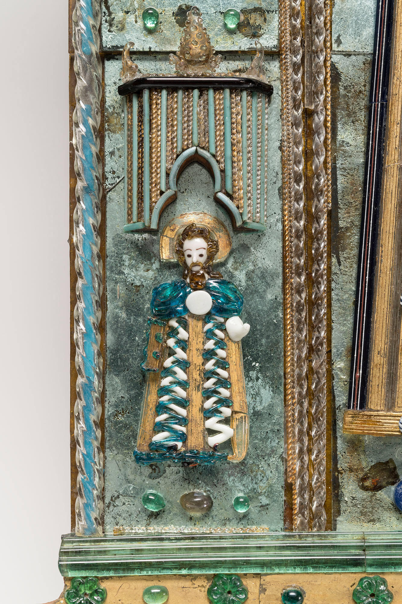 A saint with a white face and a halo made out of glass.