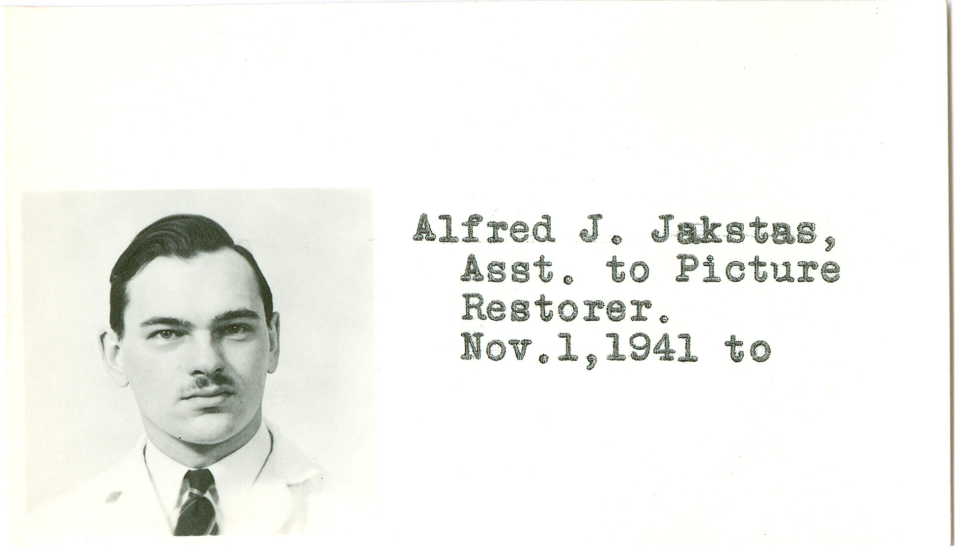 Identification card with a black and white picture of a man with dark hair and a mustache, identified on the card as Alfred J. Jakstas, Assistant to Picture Restorer as of November 1, 1941.