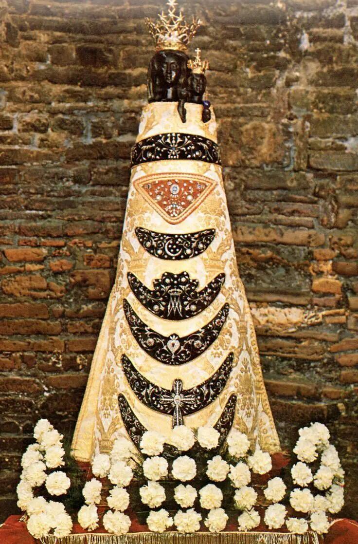 A tall sculpture of a Virgin and Child with black faces.