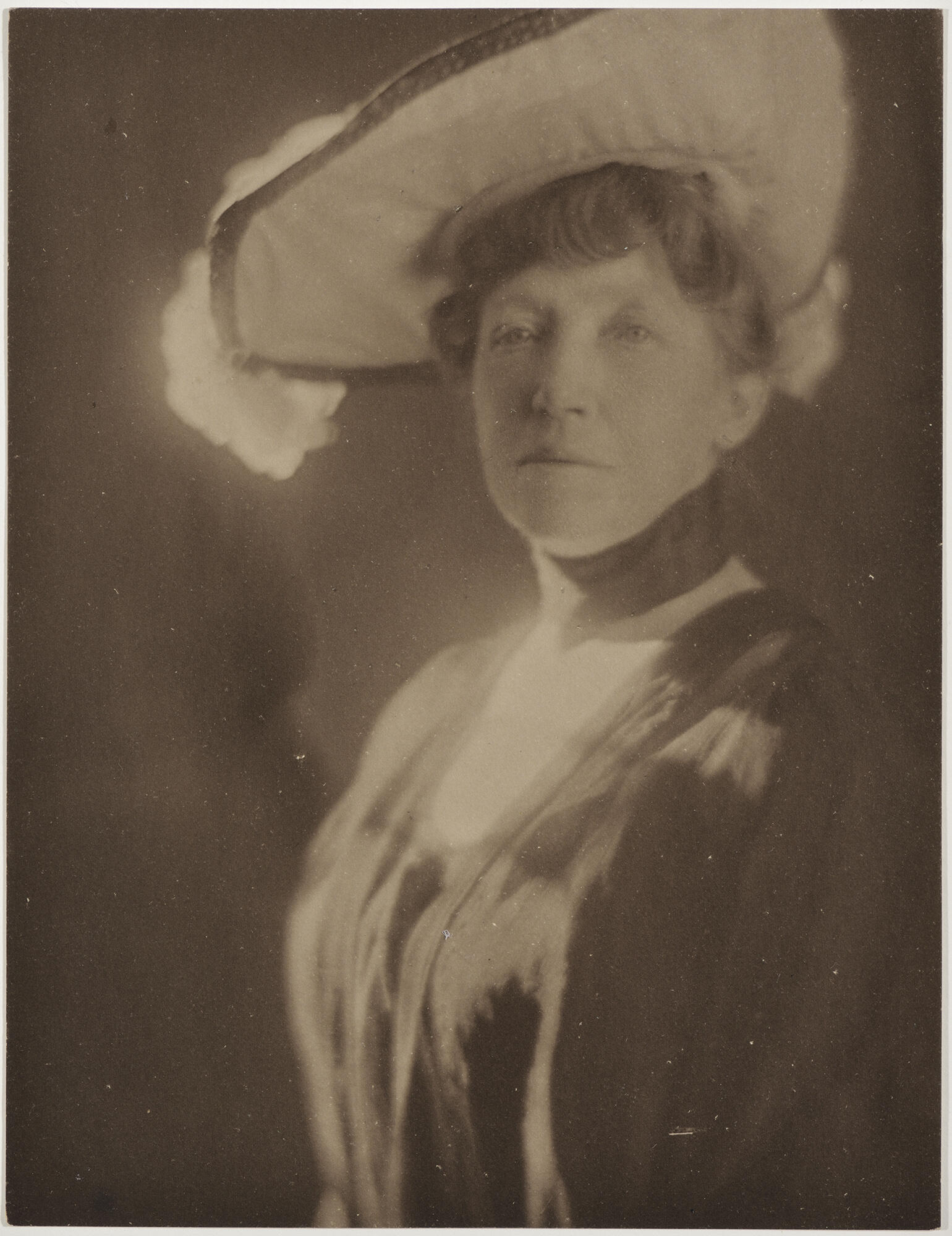  Black and white photograph of a middle aged white woman wearing a large hat.