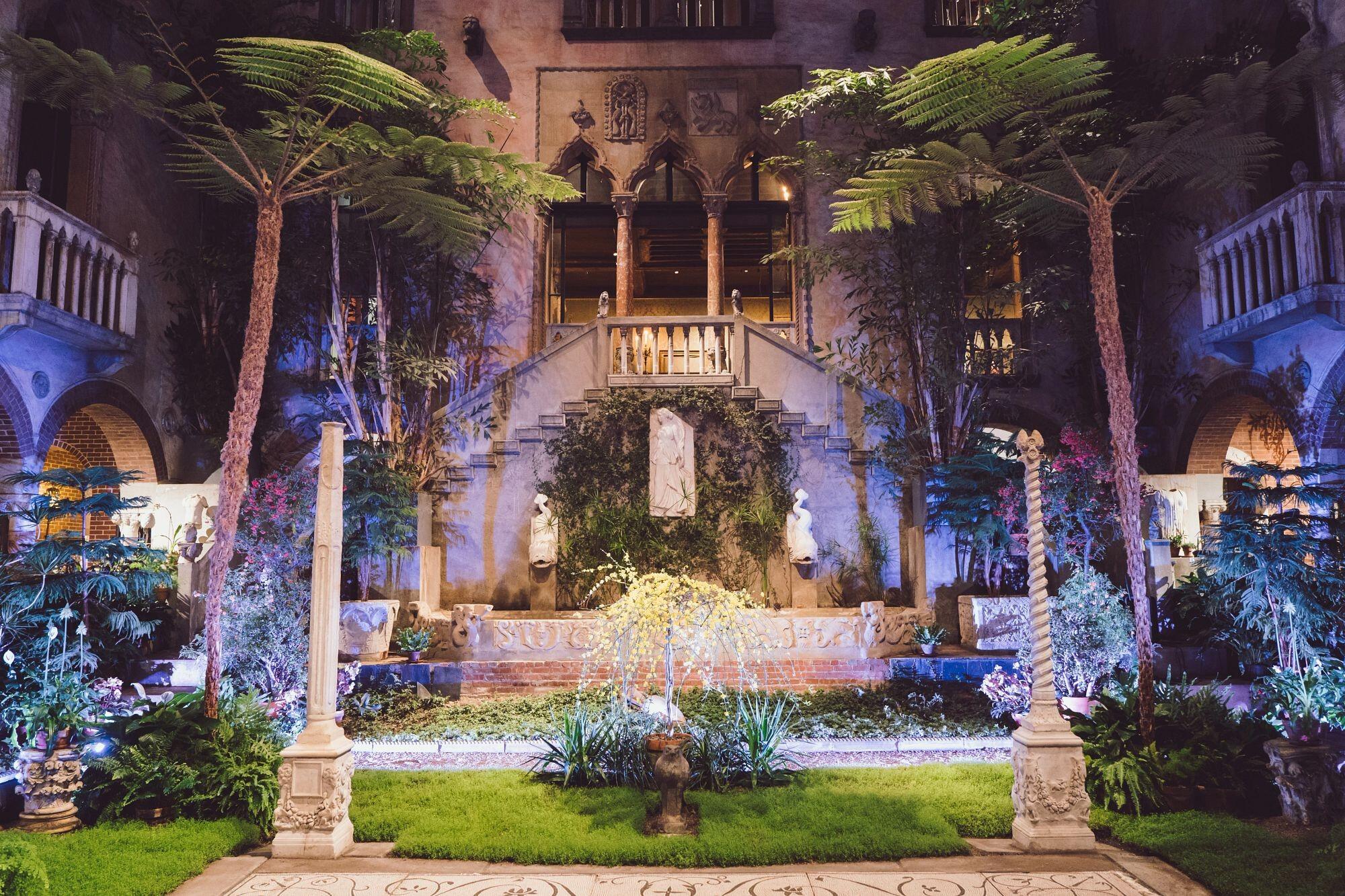 A garden courtyard illuminated by lights at night.