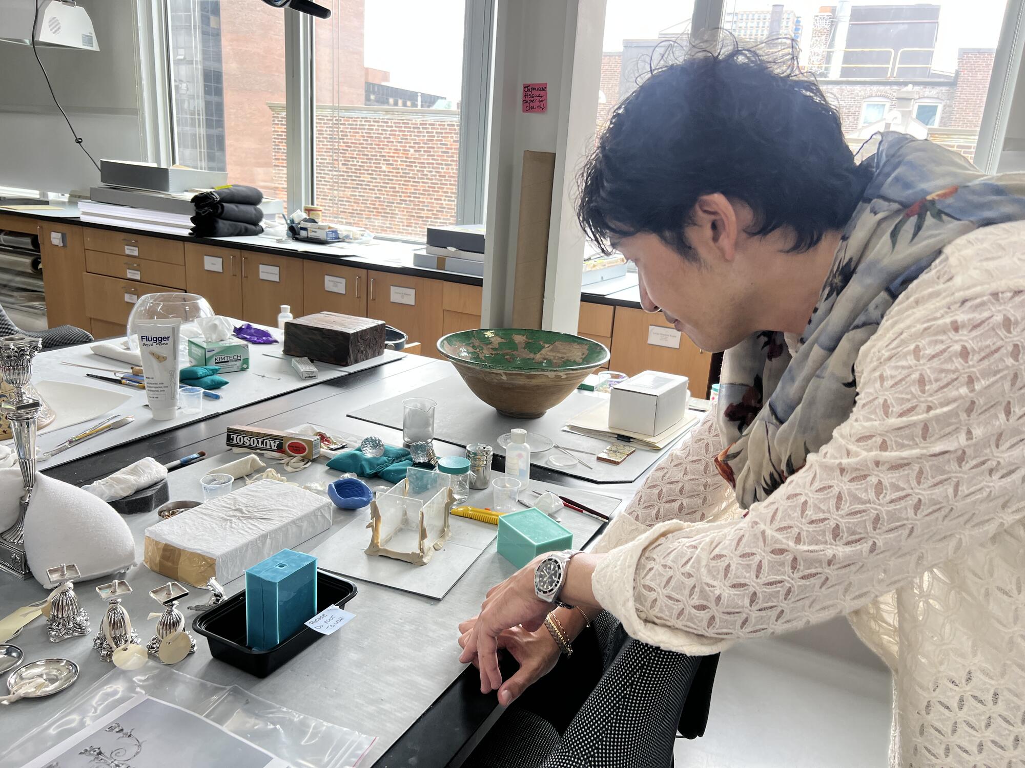 Asian man examining mold-making materials in a laboratory. 