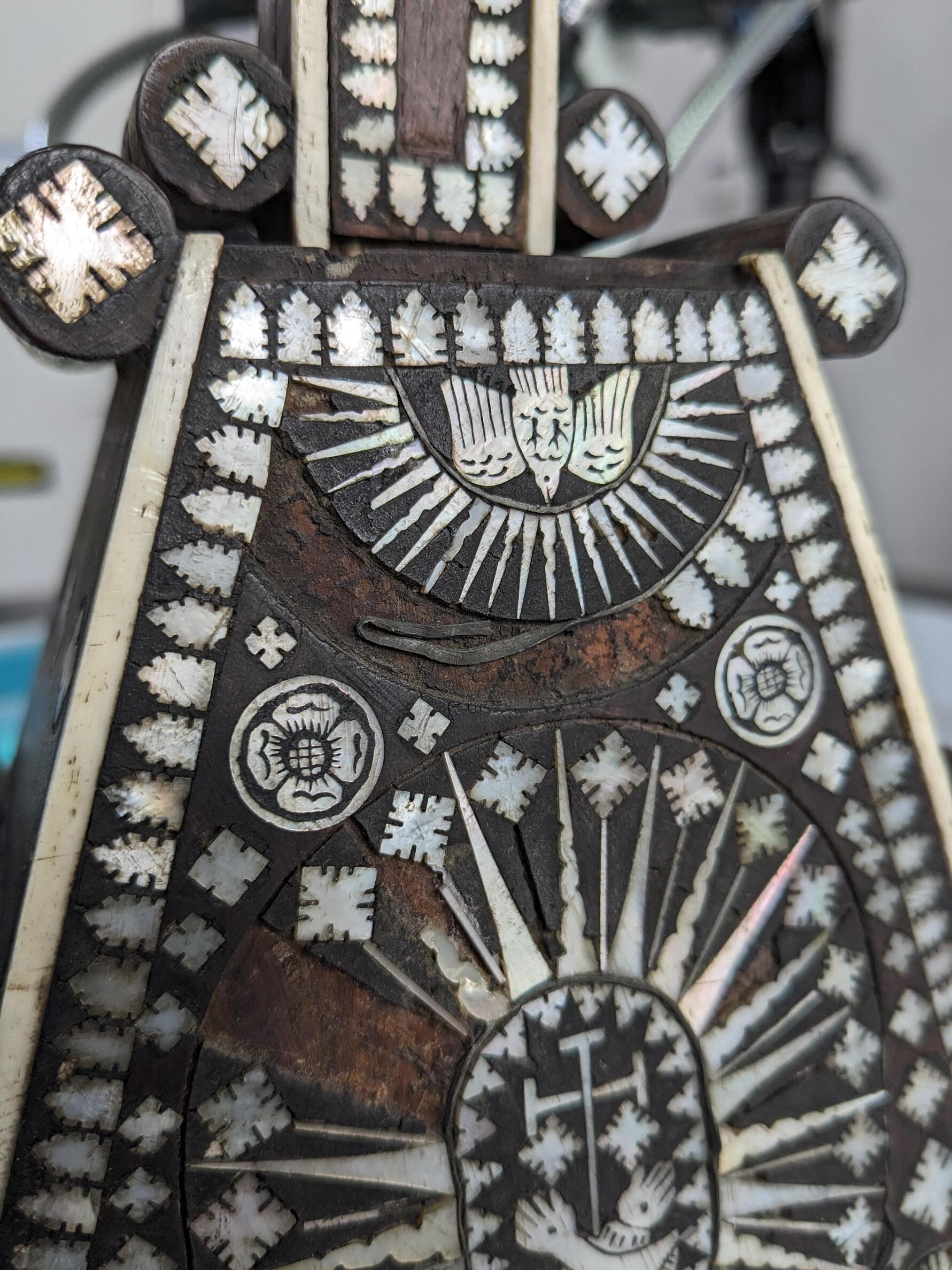 A section of metal trim on the base of the object is bent in on itself. 