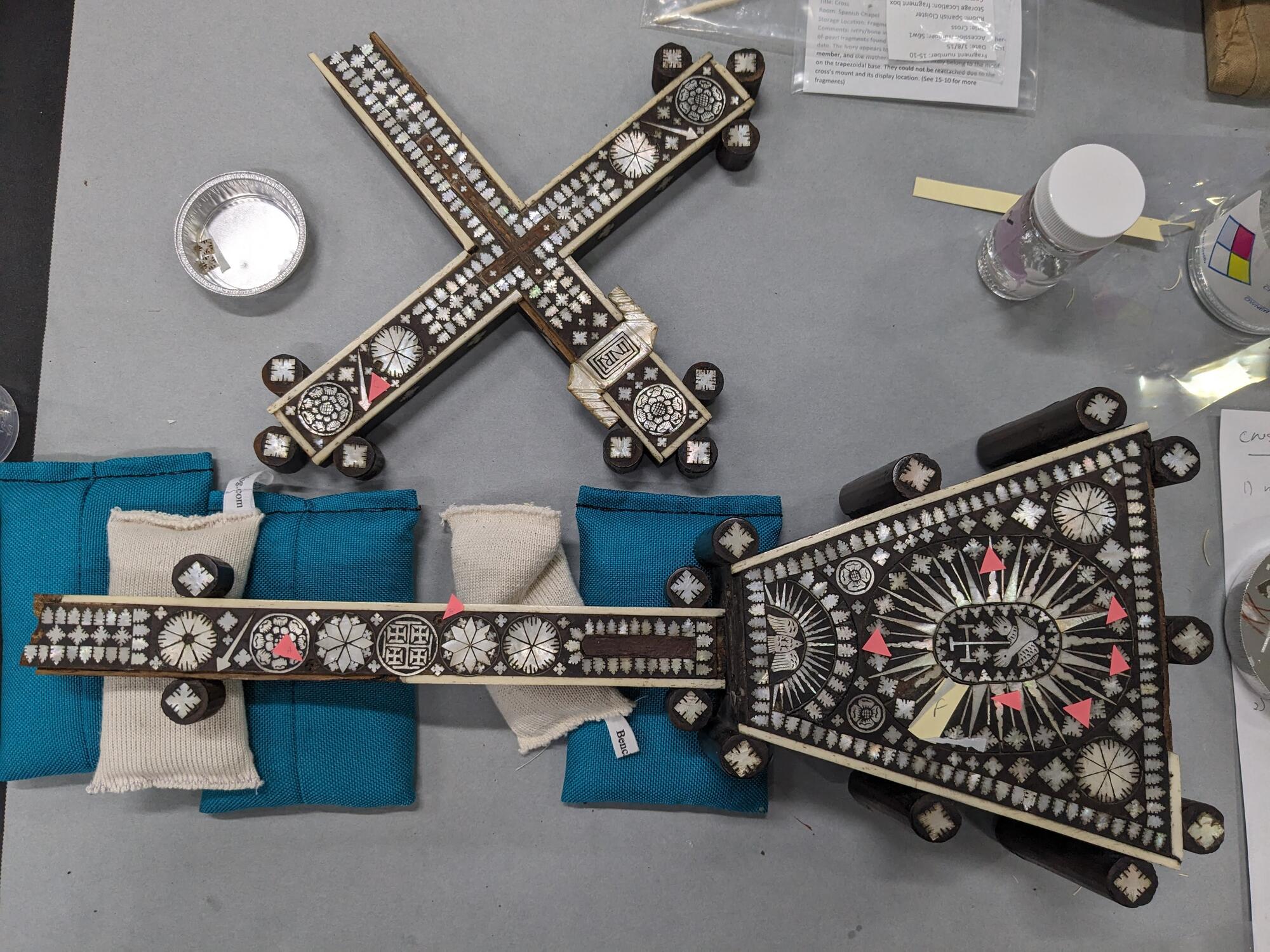 Small paper arrows point to the various areas of mother-of-pearl loss on both halves of the object.