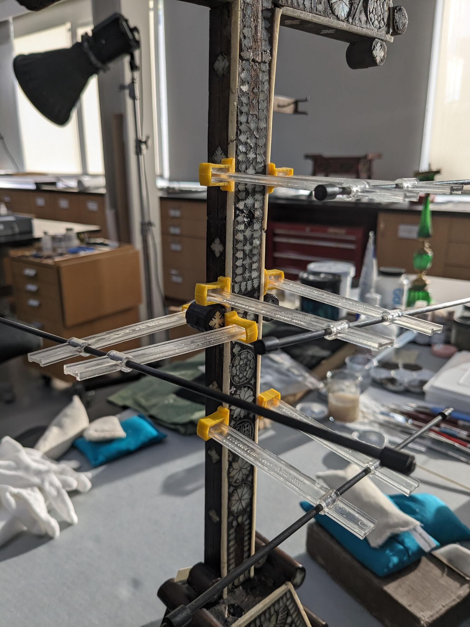 Middle of the cross with several pressure clamps to hold the bone fragment in place while the adhesive sets.