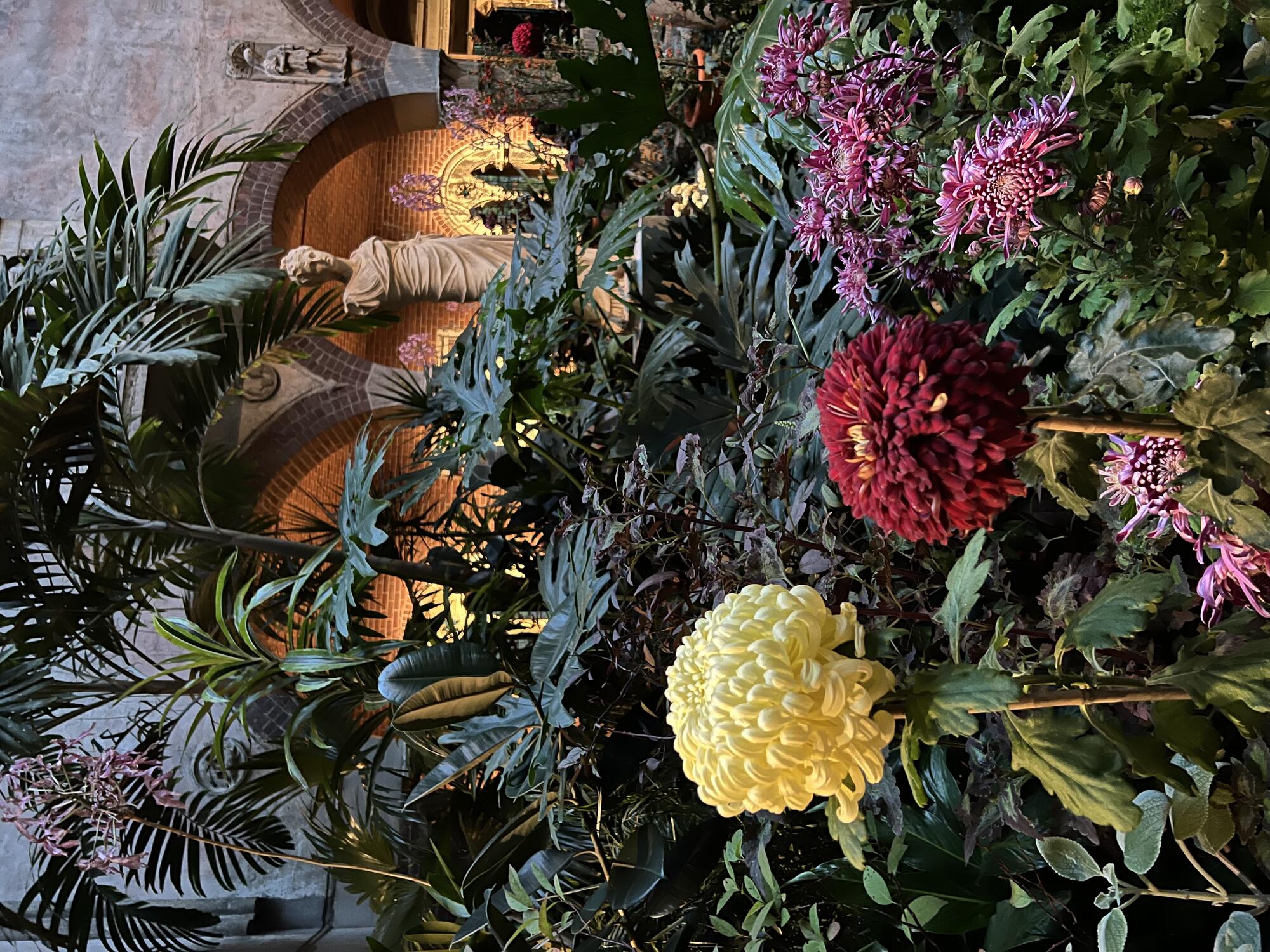 Chrysanthemums and orchids surround a statue of Persephone.