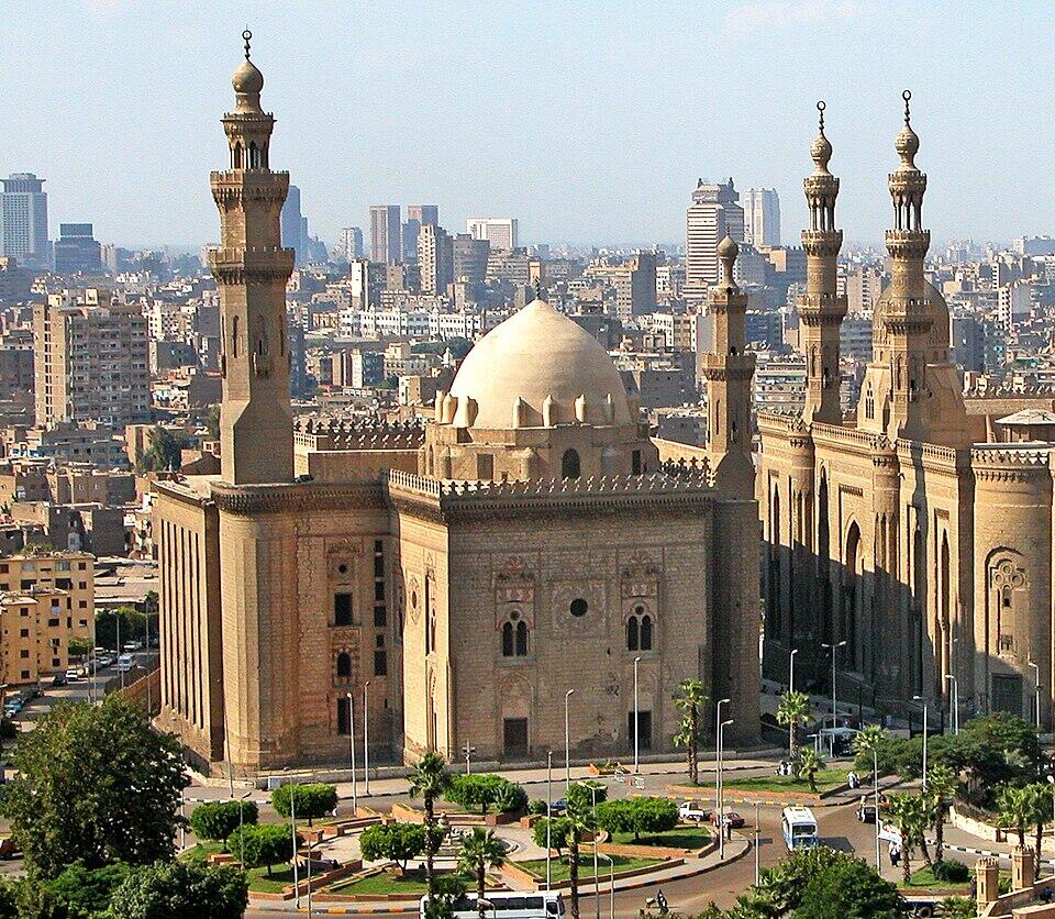 A large stone building with a dome and two minarettes.