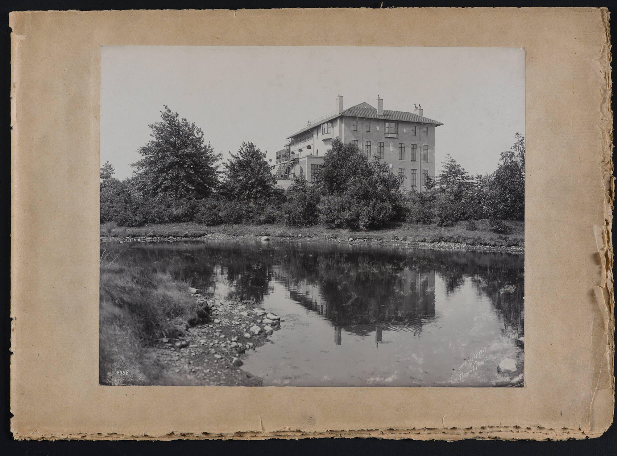A black and white photograph of the exterior of the Isabella Stewart Gardner Museum from the Fenway with the Muddy River in the foreground.