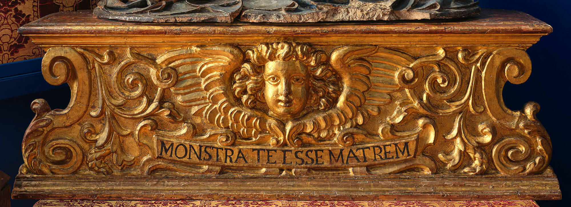 A rectangular gold base with the Latin words Monstra Te Esse Matrem.