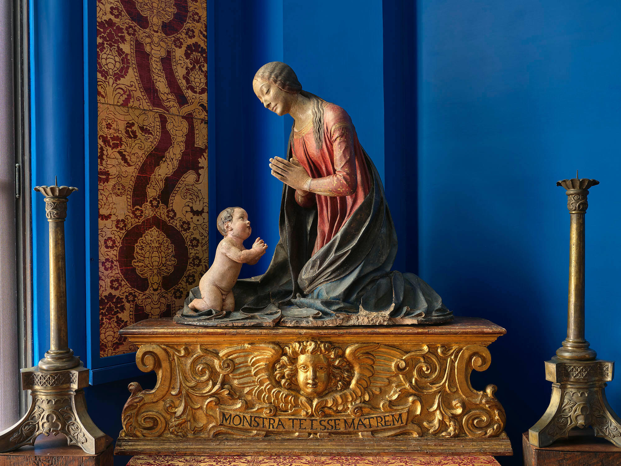 A wooden sculpture of a mother and child.