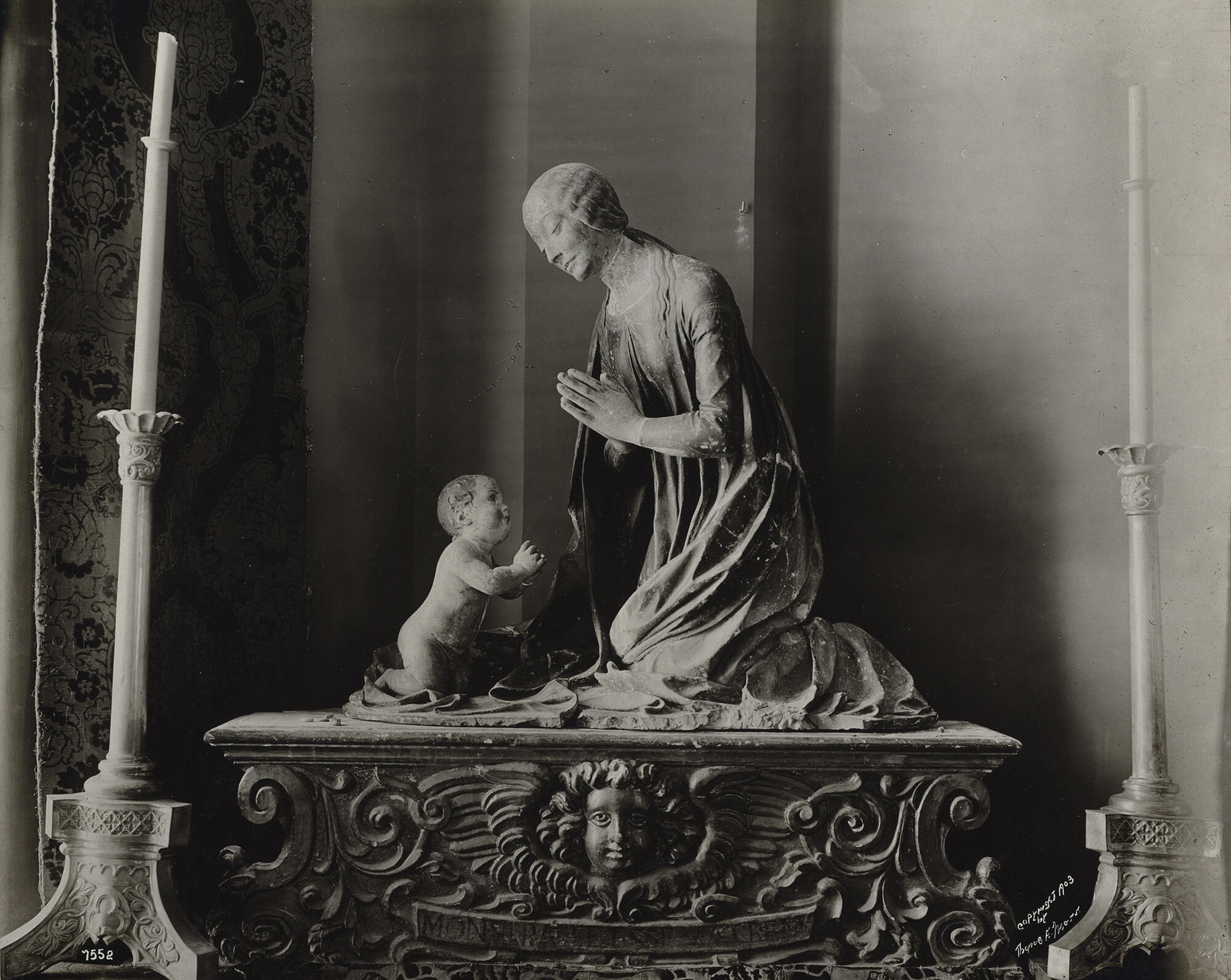 A black and white photograph of a wooden sculpture of a mother and child.