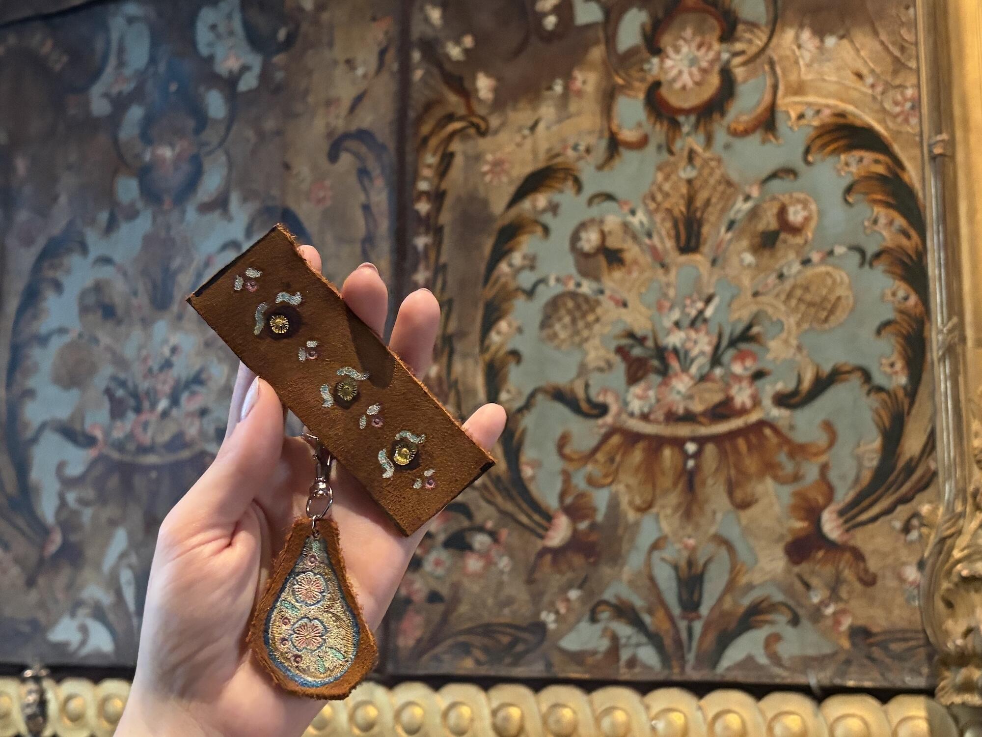 A hard displays a gilt leather object in a room with rich leather wall paneling