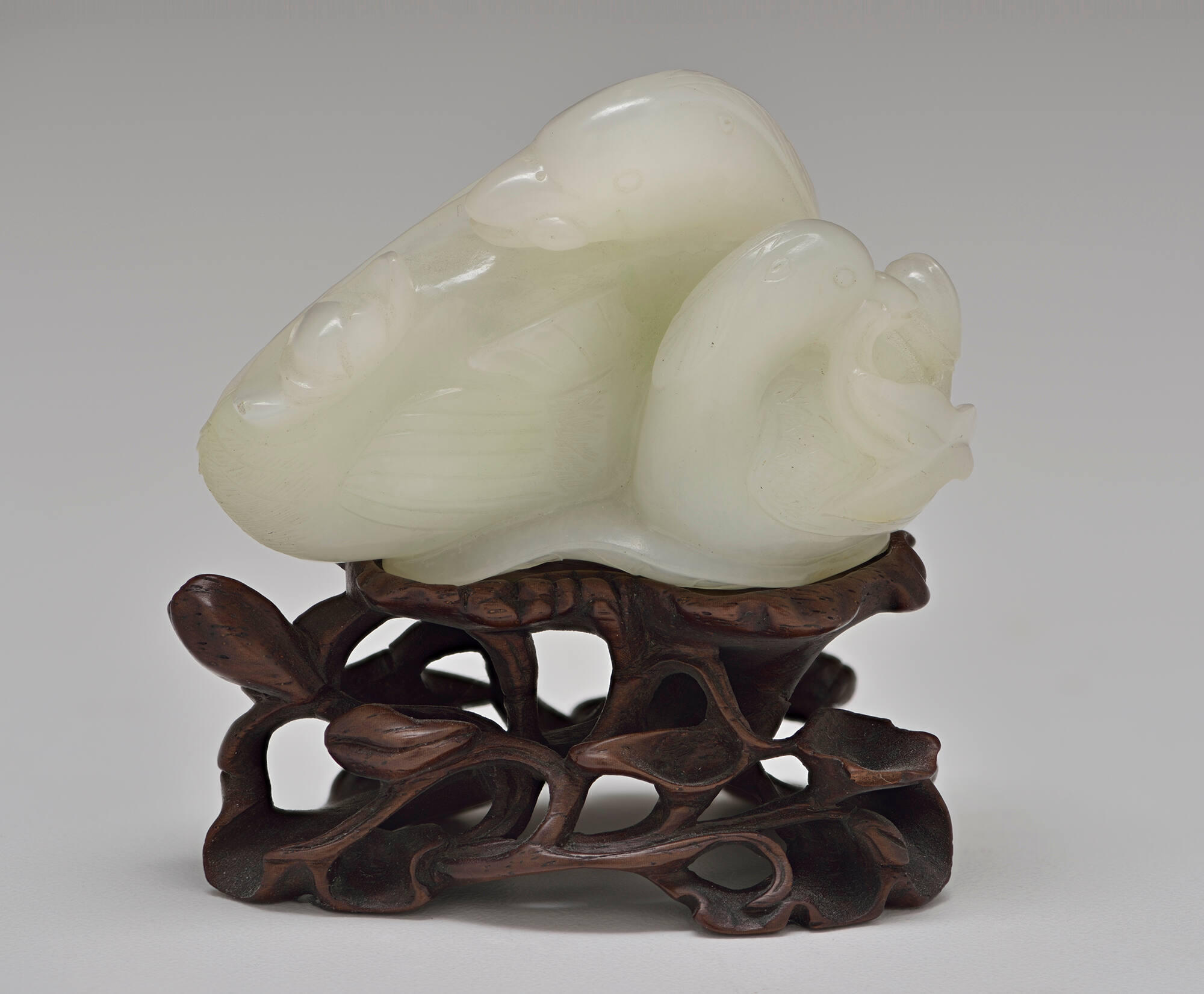 Two swans carved out of a milky green stone