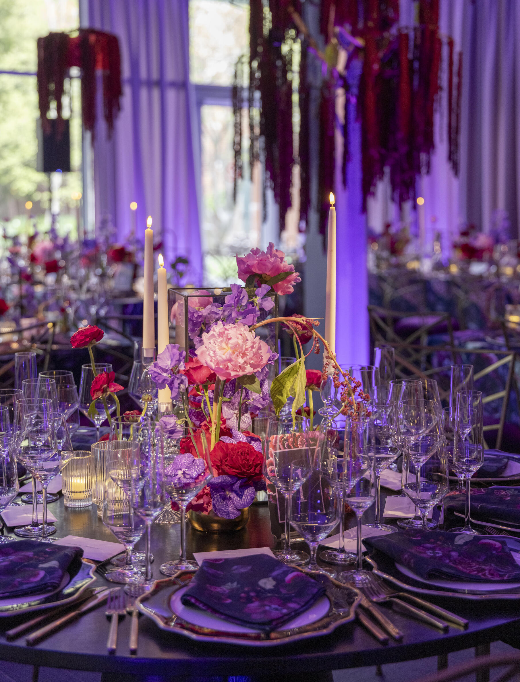 A round table decorated with flowers and set for dining