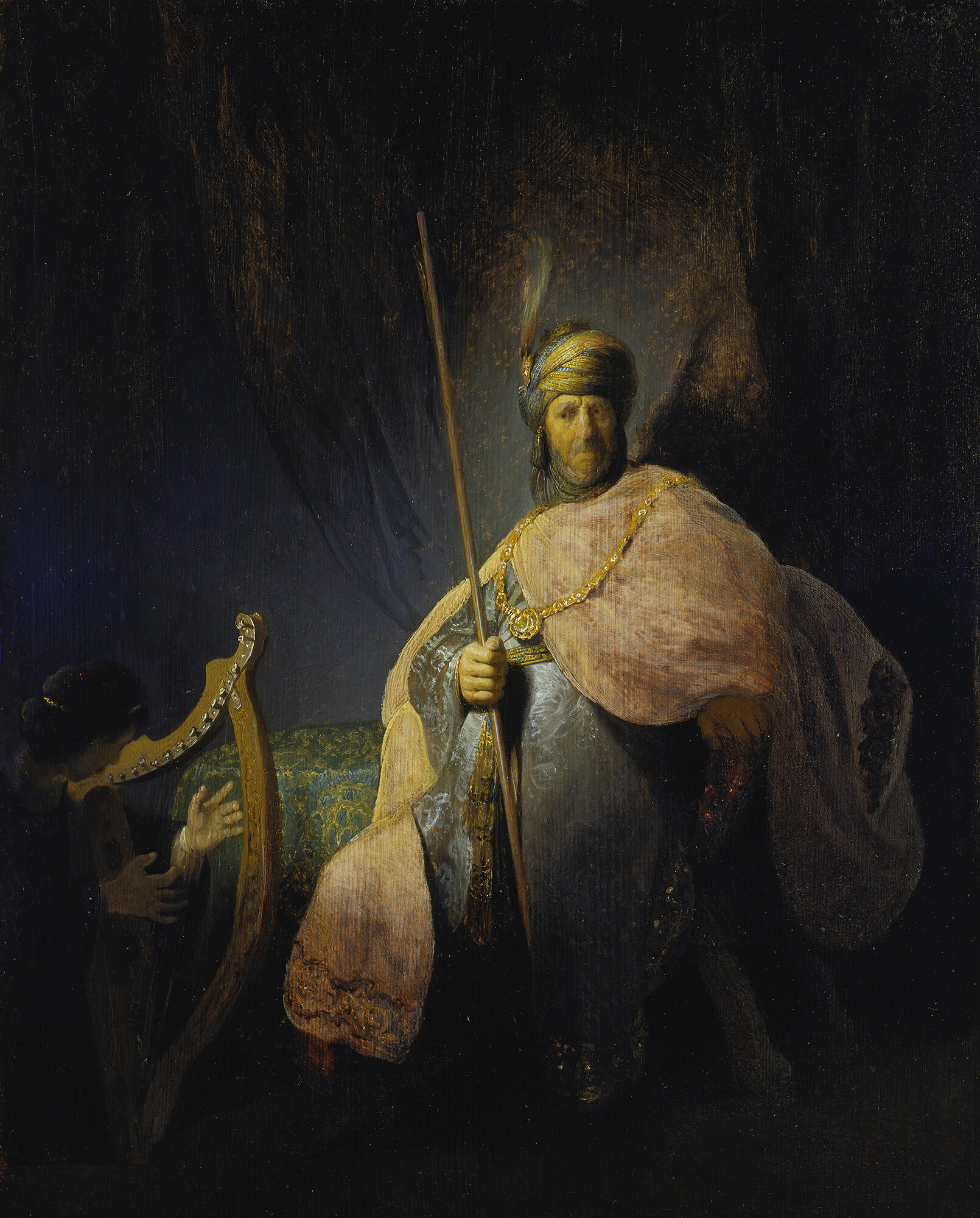 A peachy-skinned, seated man wearing a turban and voluminous robes watches a man playing a small harp.