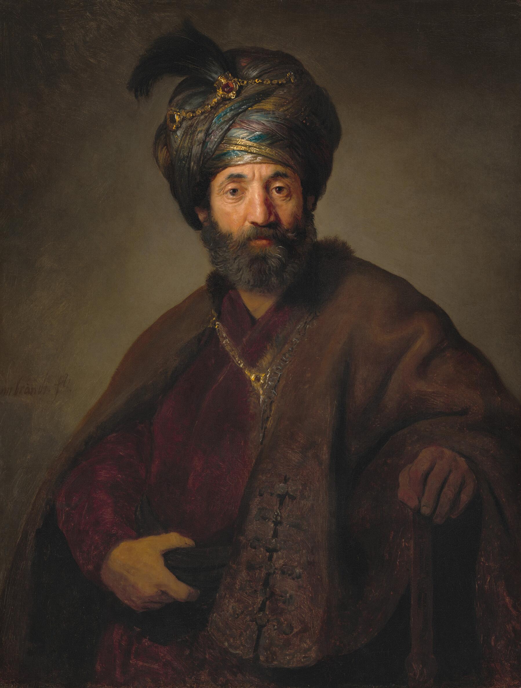 Shown from the waist up, a bearded man with a tanned, peachy complexion wears a turban accented with a gold chain and feather, and voluminous robes.