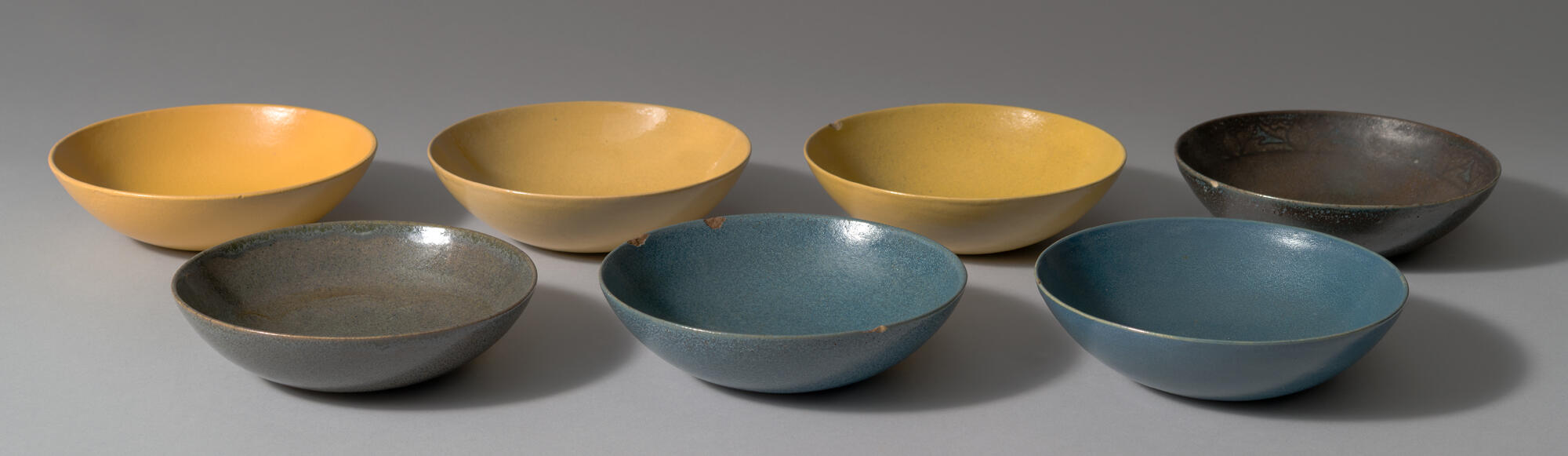 Three yellow, two dark green, and two blue bowls.