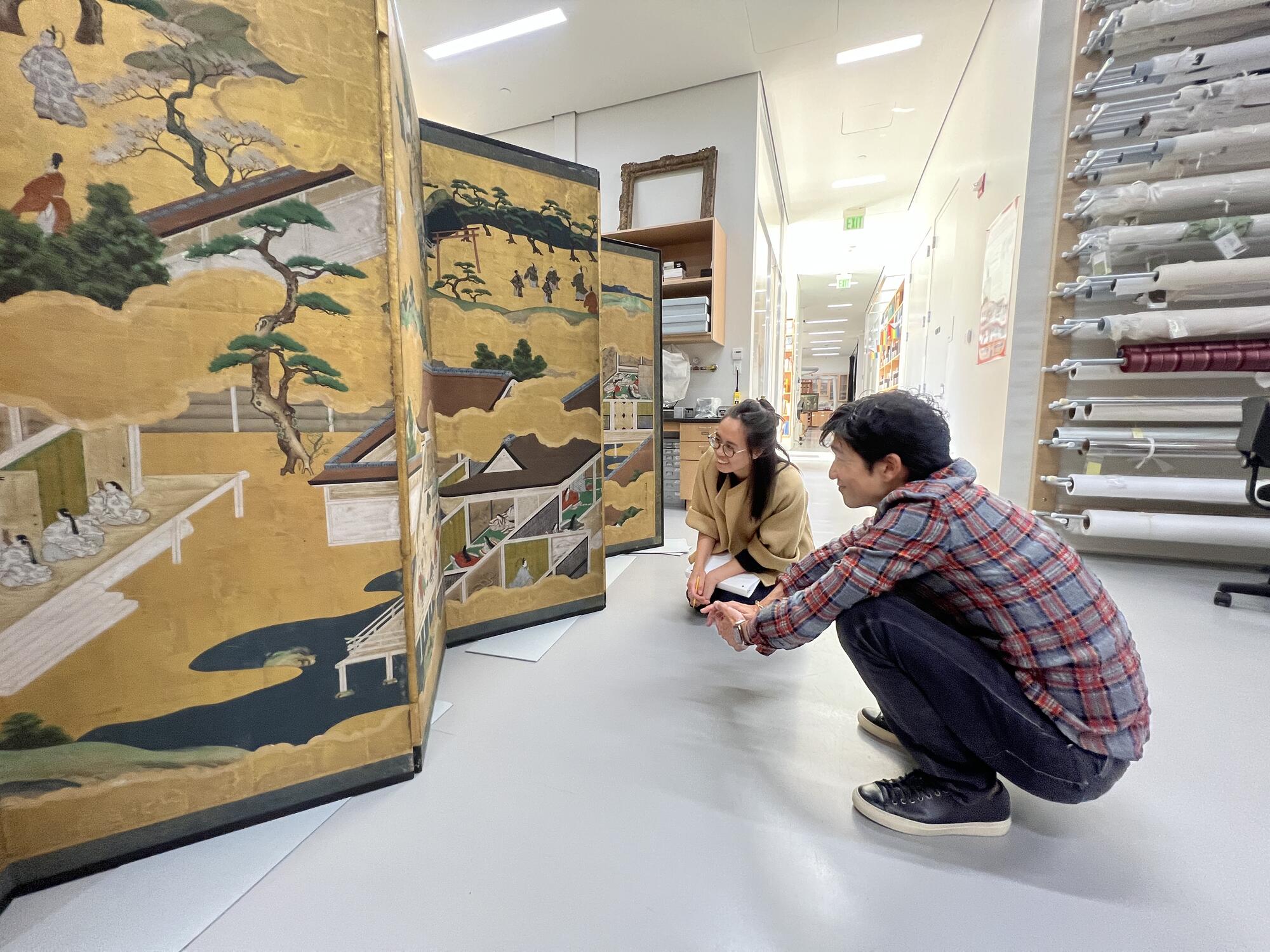 Matsu and Gabrielle examining a pair of screens