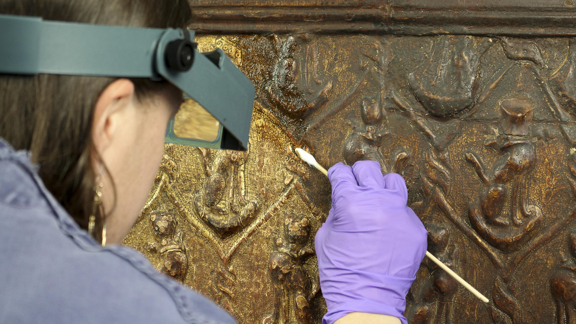 Objects conservator Holly Salmon reduces discolored varnish from the gilt surface of a cassone in the conservation lab at the Isabella Stewart Gardner Museum