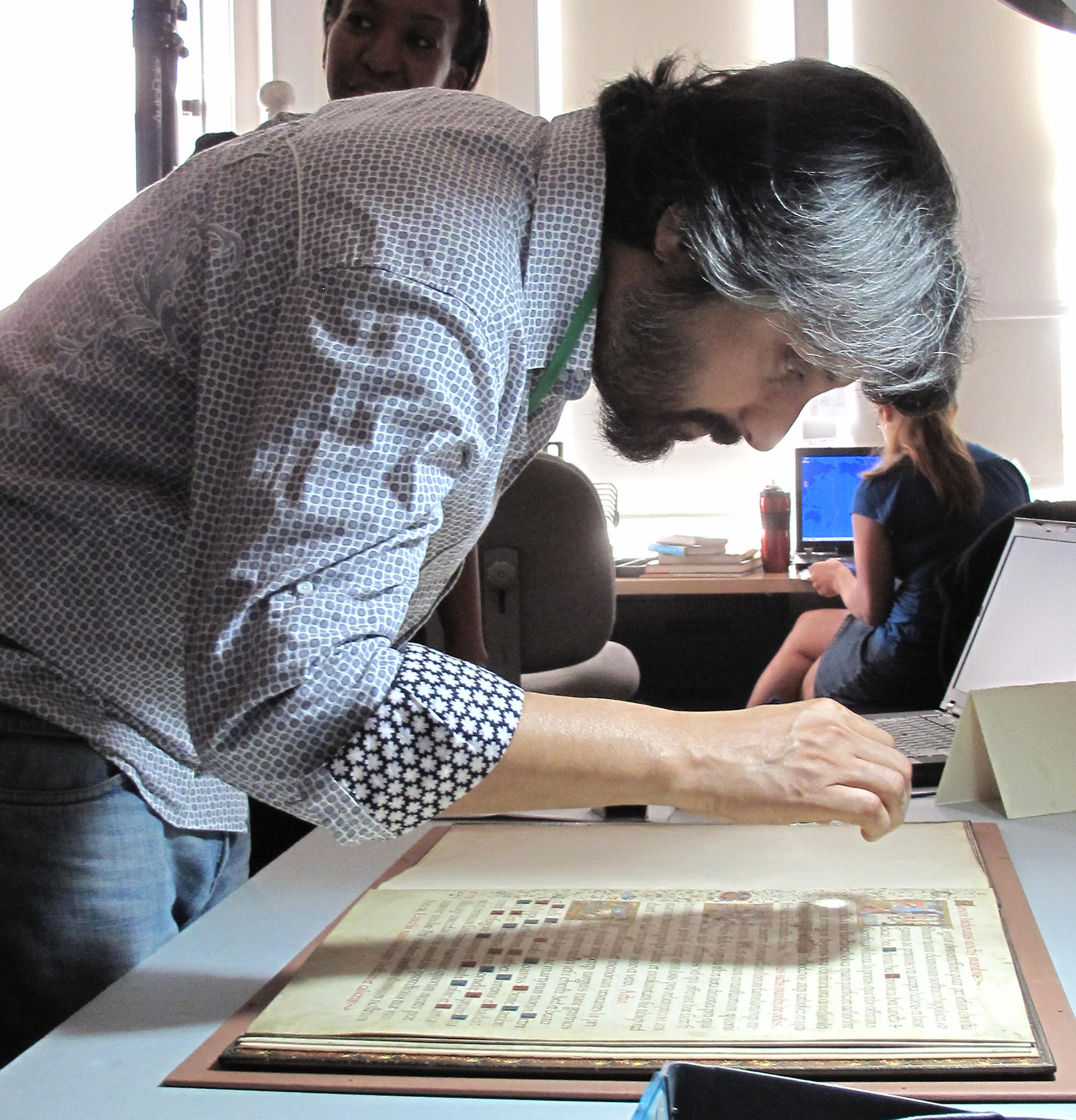 Jeebesh Bagchi of the Raqs Media Collective examining Leaves from a Missal made for use by Pope Clement VII (Giulio de' Medici, 1478-1534).