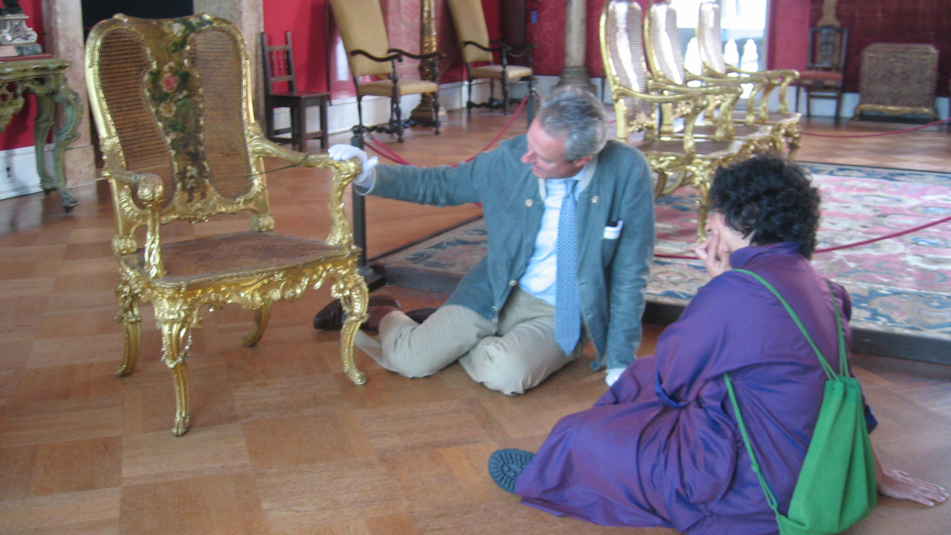 Dayanita Singh and historian Fausto Calderai discuss the personality of a gilded and painted chair in the Titian Room.