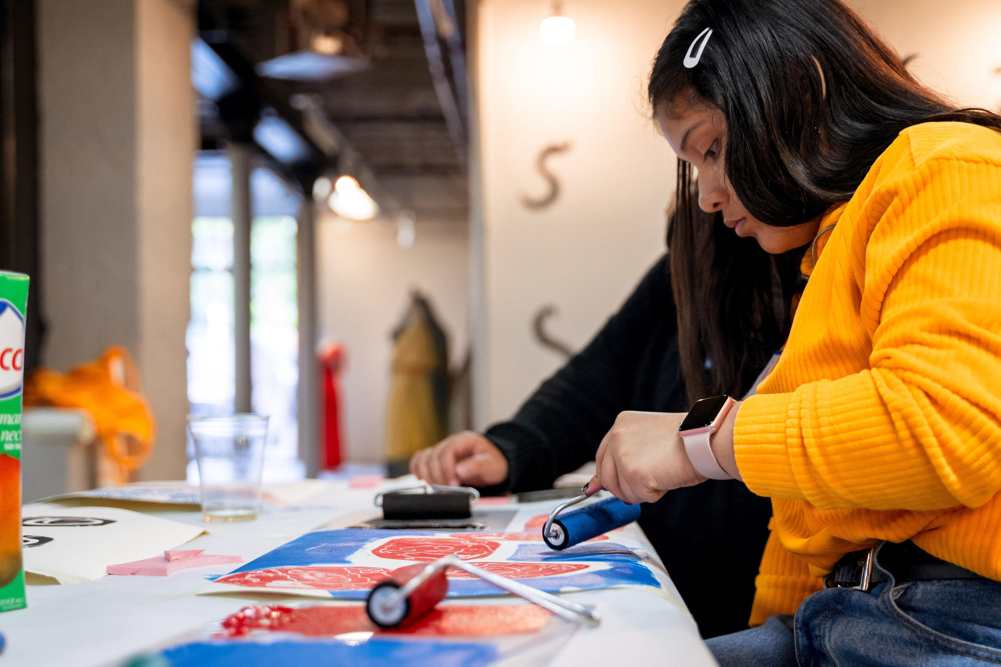 An Urbano Project student rolls paint over a linoleum tile, the next step in print-making. Photo by Faizal Westcott, June 2019.