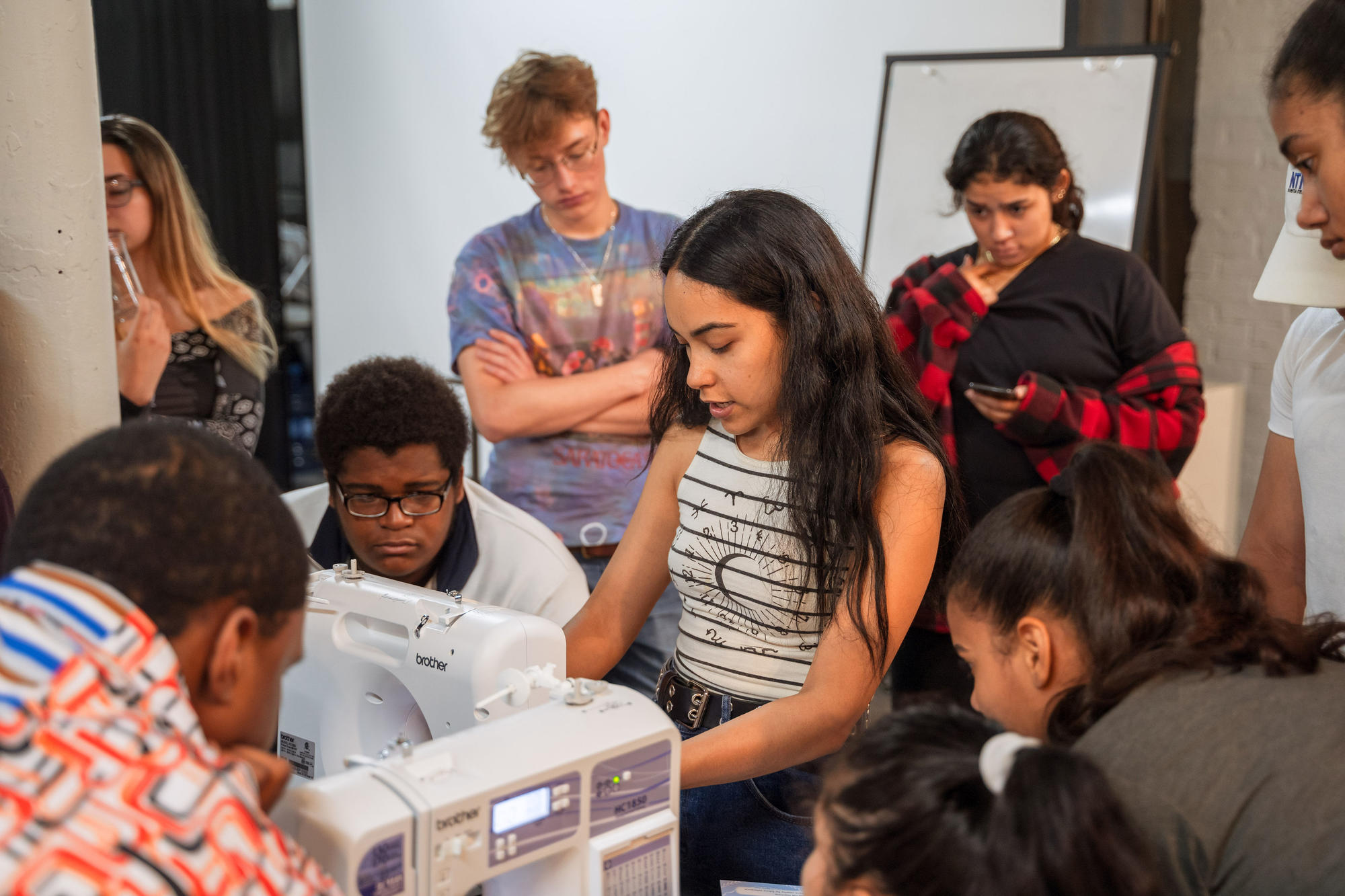 Nathalia JMag teaches Urbano Project students how to use a sewing machine.