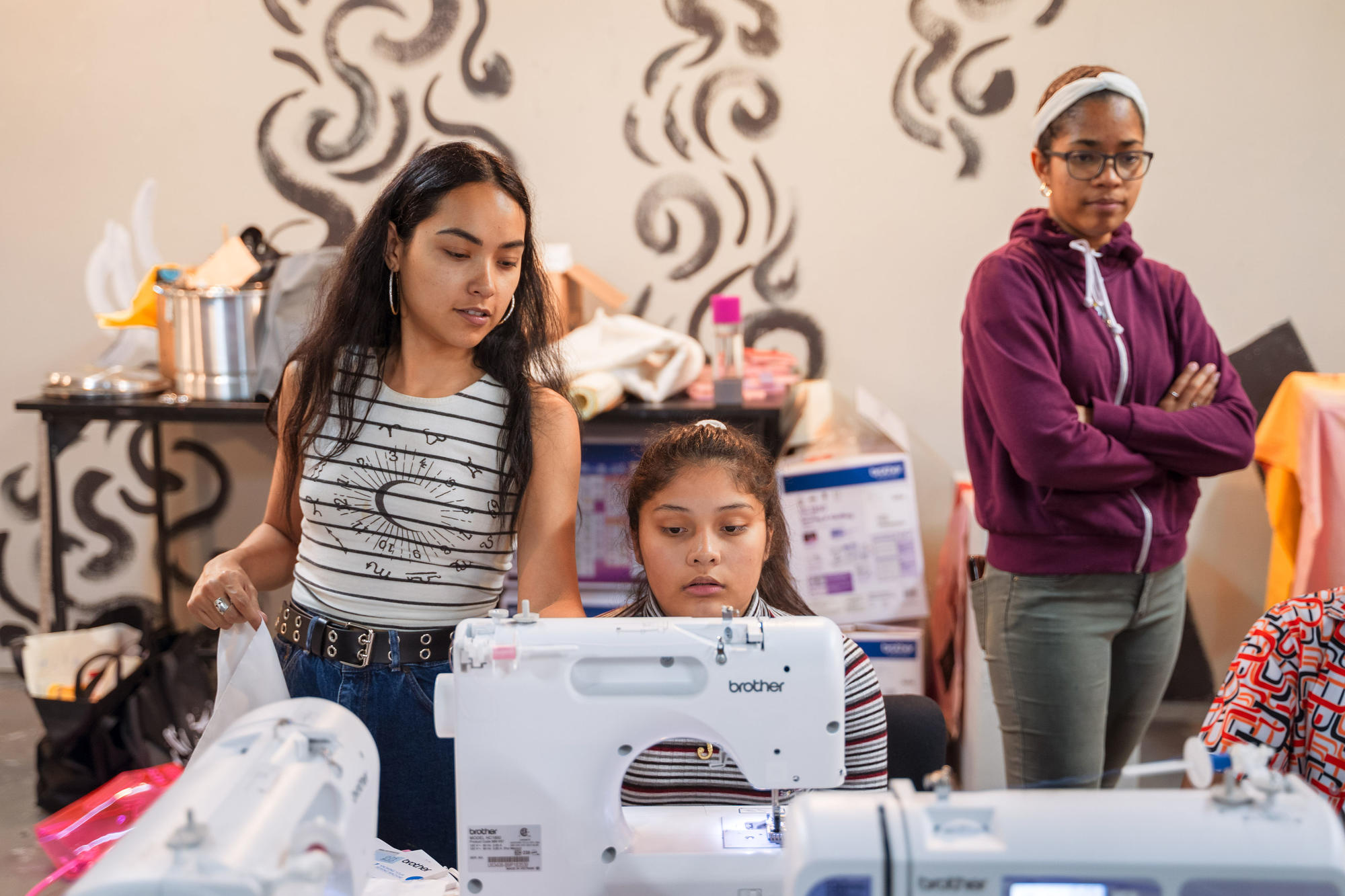 Nathalia JMag teaches Urbano Project students how to use a sewing machine.