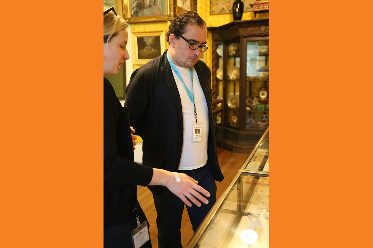 Javier Téllez examines objects in the galleries with Senior Archivist Shana McKenna.